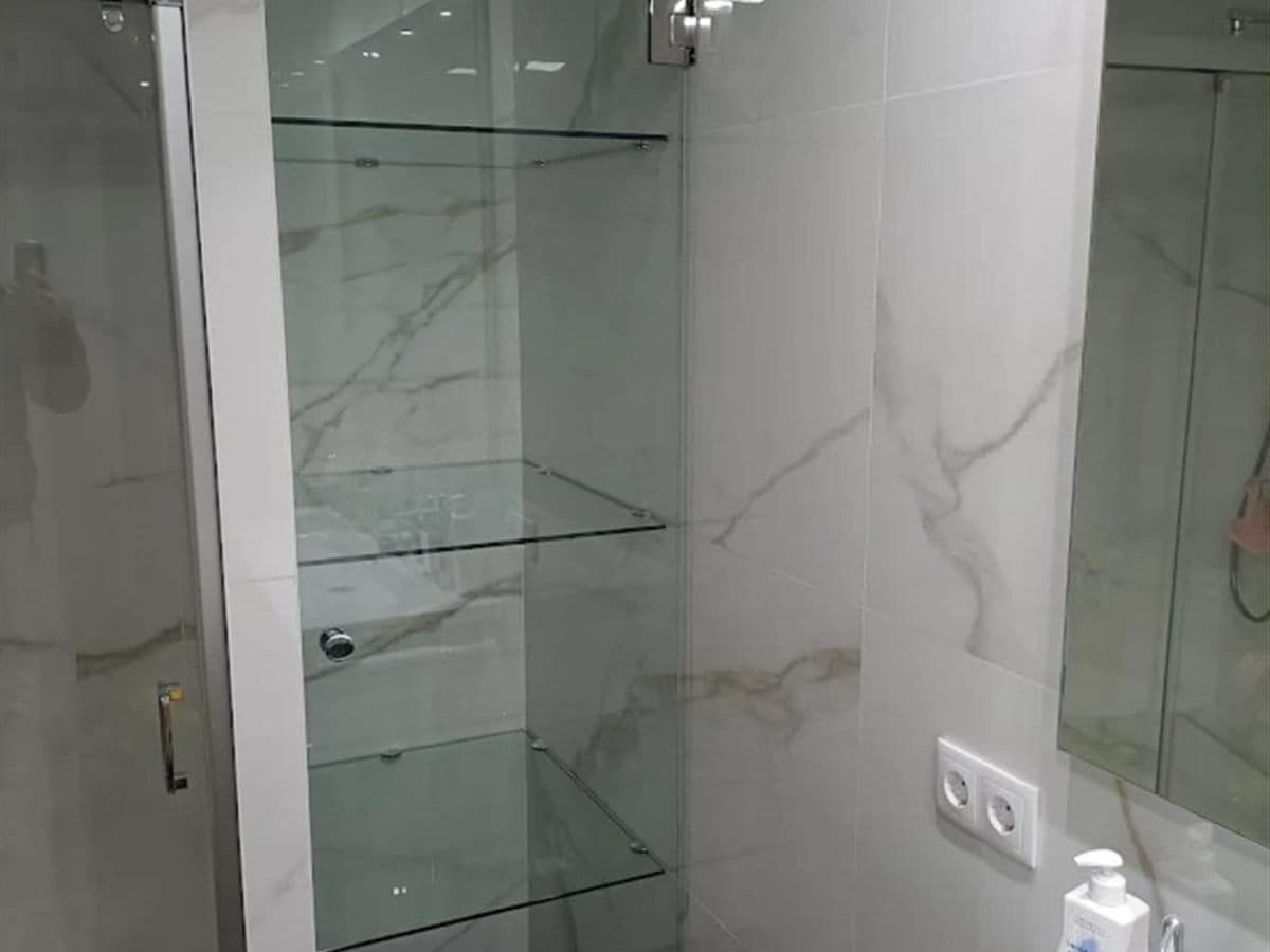 Estantes de cristal a medida montados en una vivienda de Vigo
