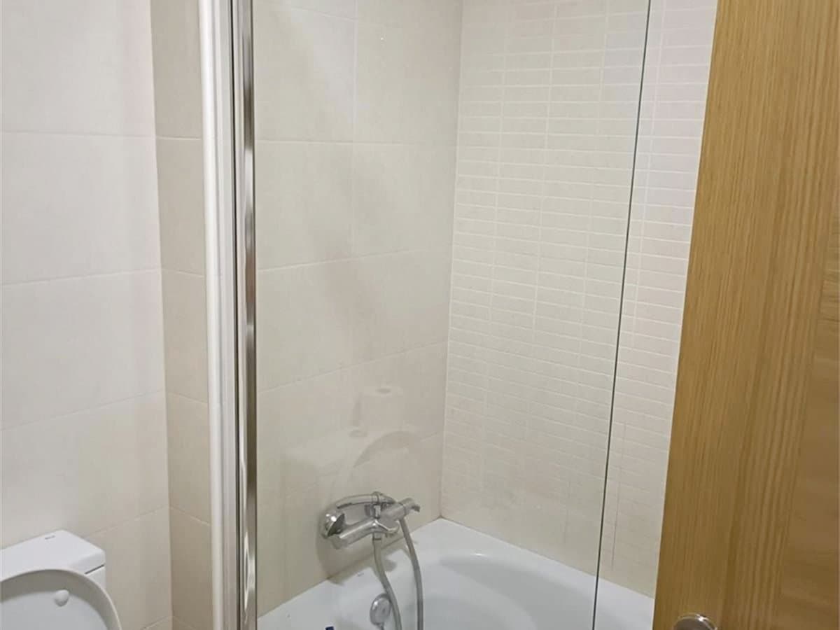 Mampara de ducha corredera con riel instalada en un baño pequeño de Vigo