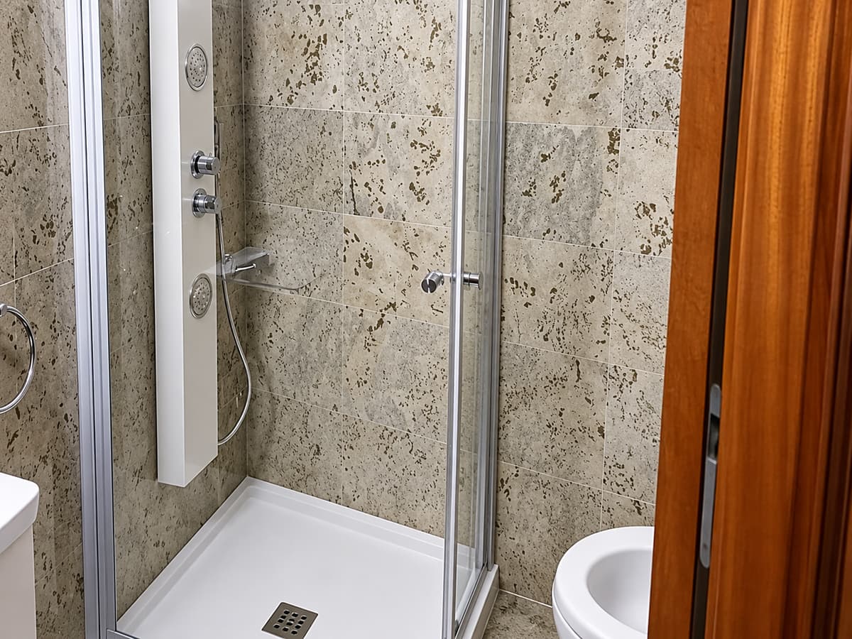 Mampara fija de cristal sin marcos en un baño minimalista de Vigo