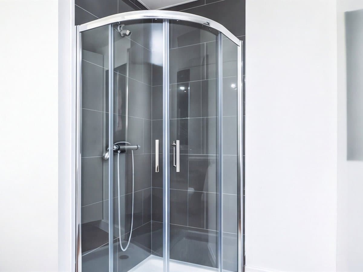 Mampara de ducha de cristal a medida instalada en un baño en Vigo